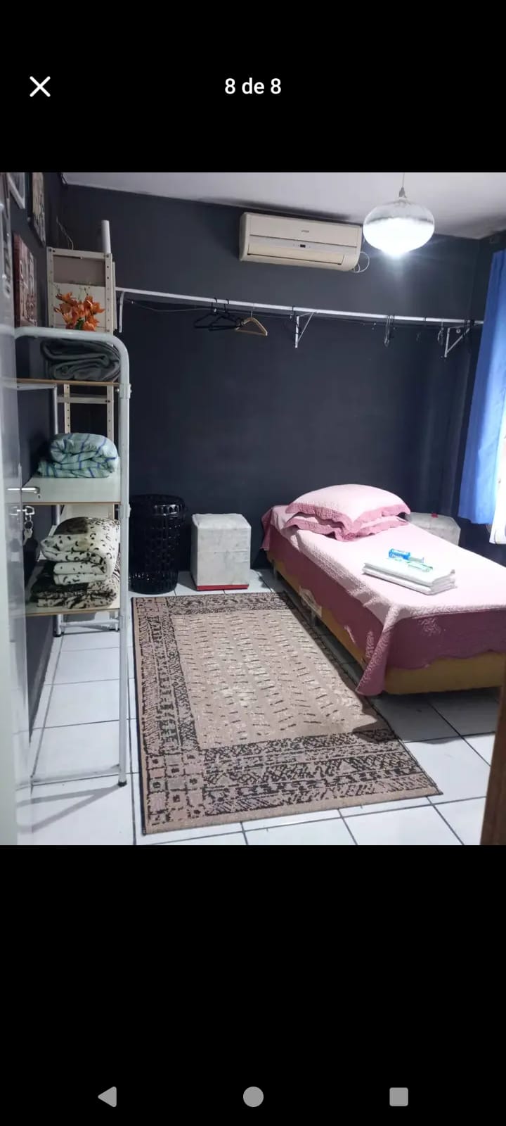 Quarto com roupa de cama rosa e ar-condicionado