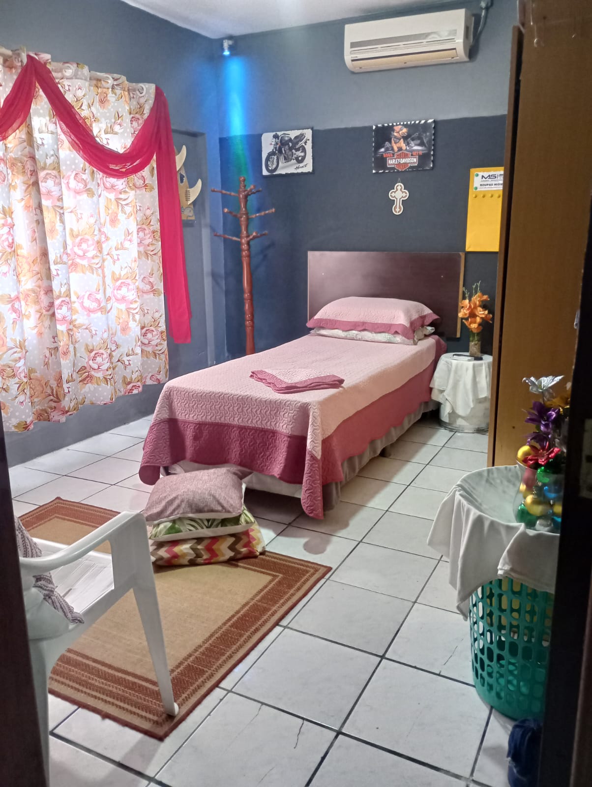 Quarto 1 da Pousada Gaspar: cama de solteiro, ar-condicionado e cortina floral